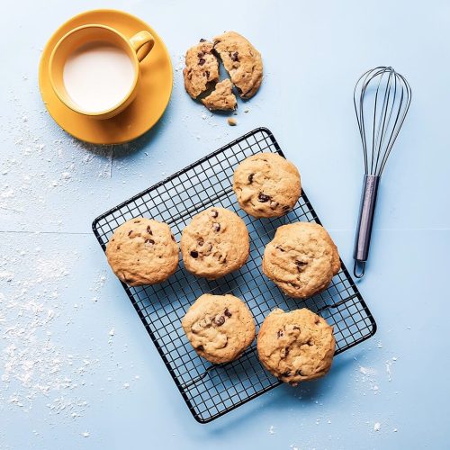 cookies sobre fondo azul y taza de leche